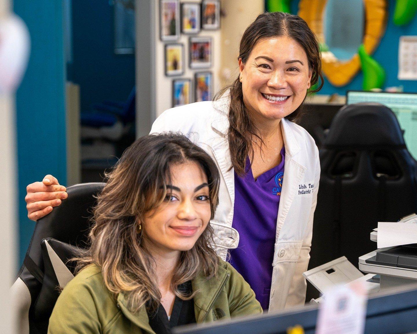 Dr. Tsai and a front-office team member smiling together at the front desk