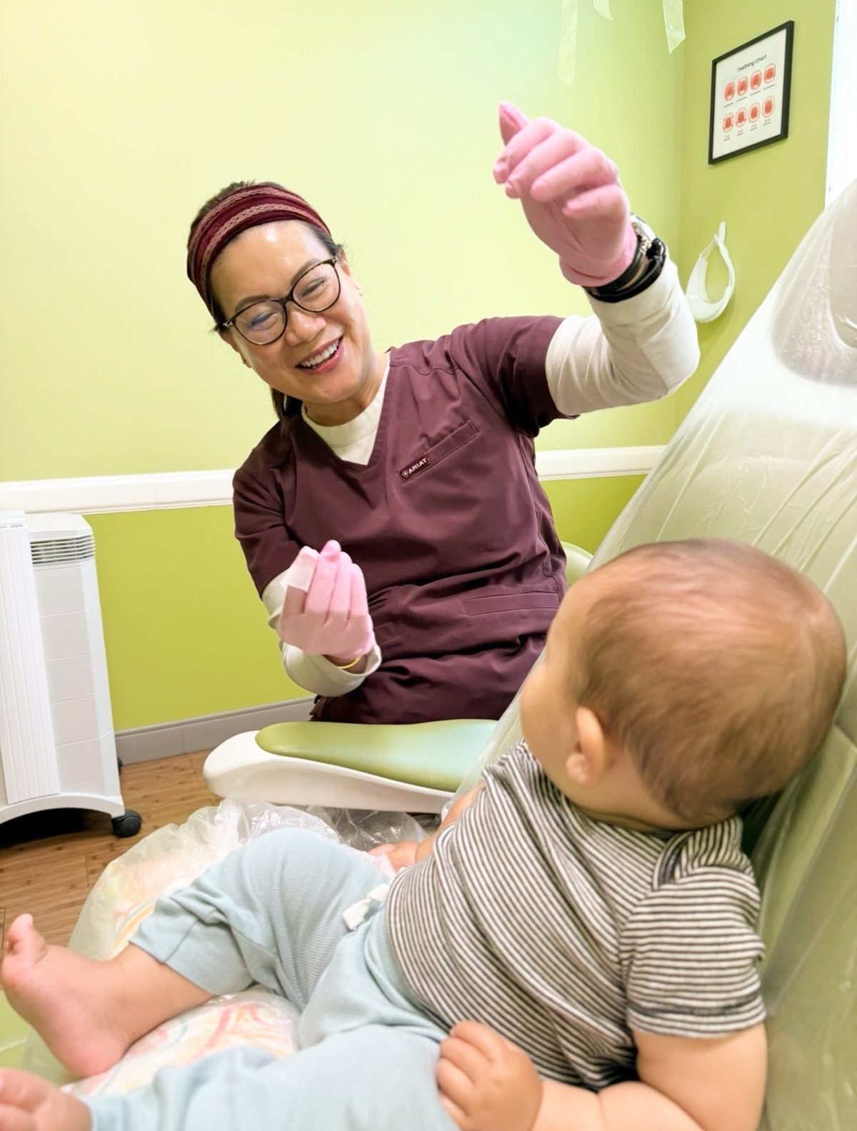 Dr. Linh Tsai playing with an infant patient during a first visit