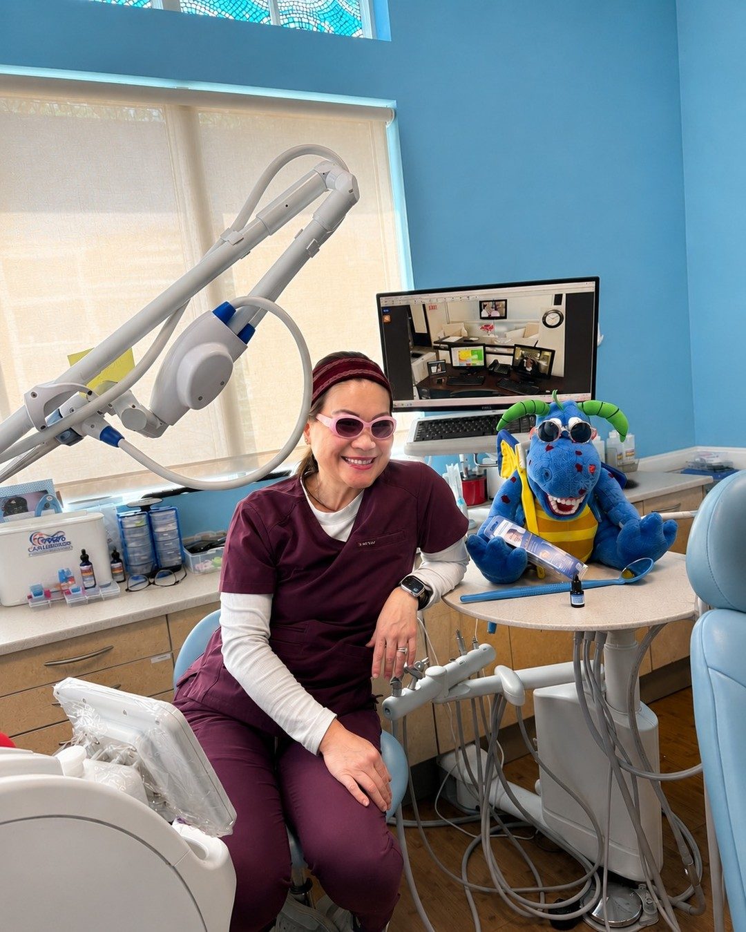 Dr. Tsai being playful with the office dragon puppet in a treatment room