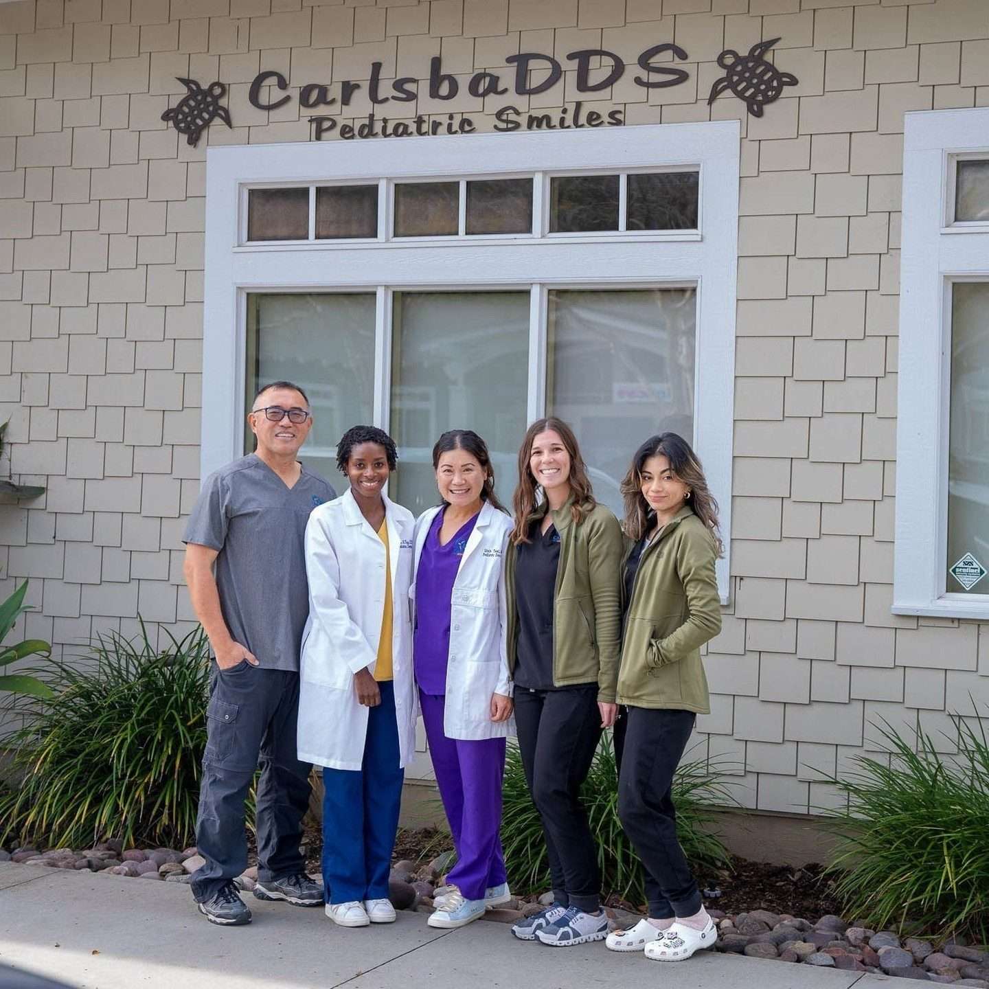 The doctors and team outside the CarlsbaDDS Pediatric Smiles storefront in Carlsbad Village