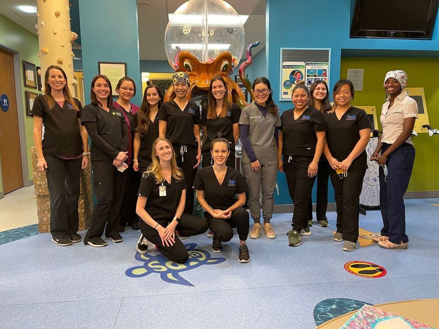 The CarlsbaDDS Pediatric Smiles team gathered in the lobby beside the octopus toy machine