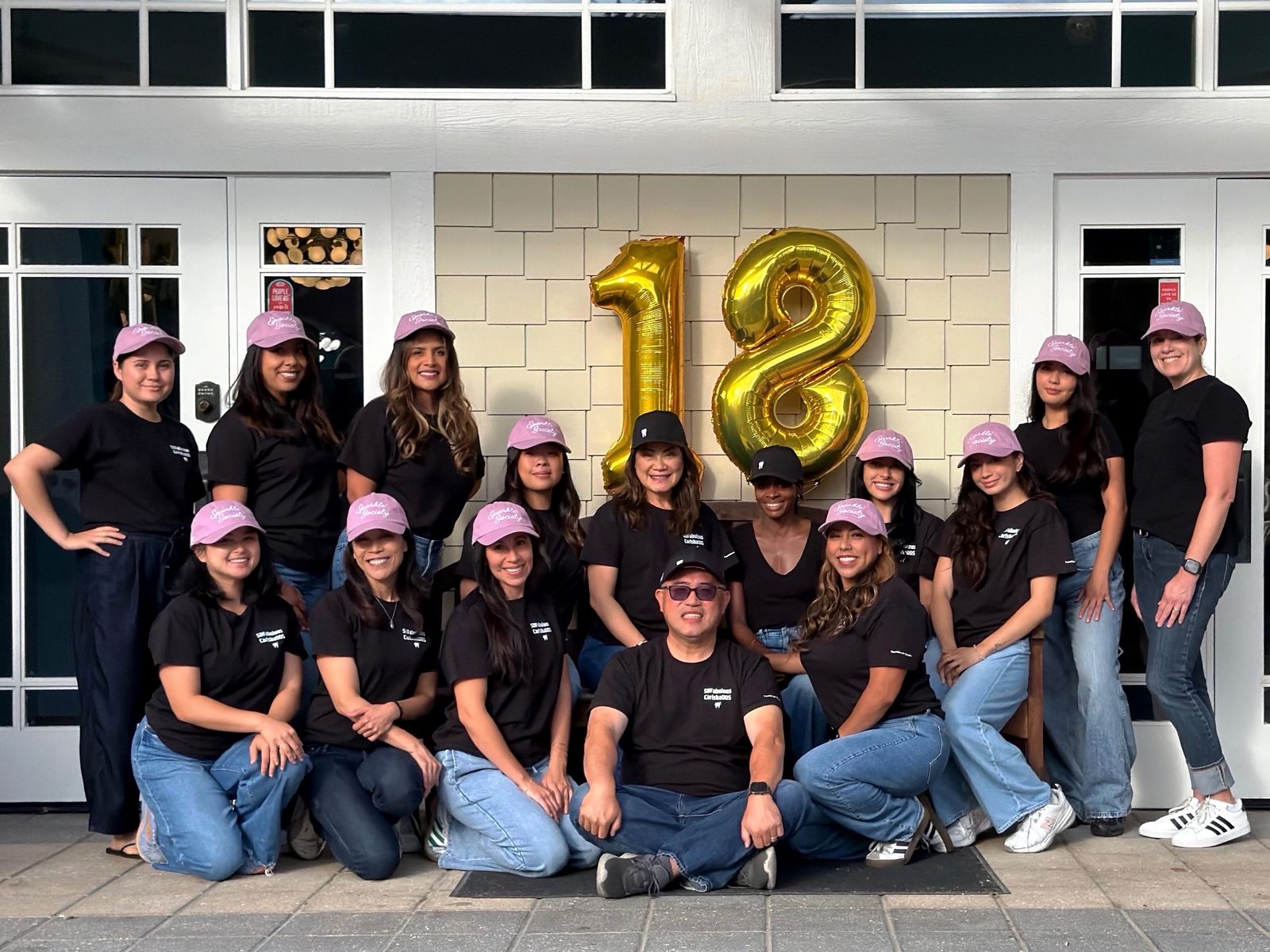 The CarlsbaDDS Pediatric Smiles team celebrating 18 years in front of the office