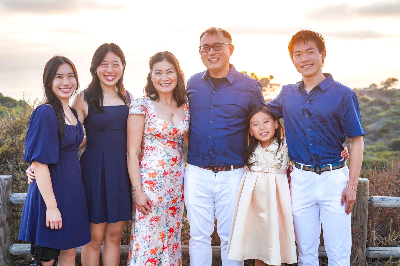 Dr. Linh Tsai with her husband James and their four children on the coast at golden hour